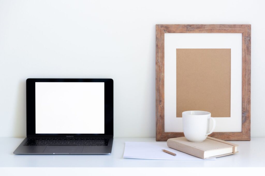 How Can I Manage ADHD-Related Emotional Dysregulation in Daily Life? 5 Empty frame placed near cup of coffee on closed notepad and white paper with empty screen of computer aside against white background