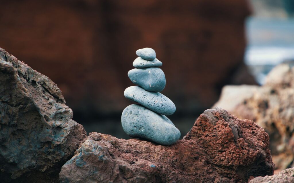 How Can I Manage Anxiety-Related Intrusive Thoughts That Disrupt My Focus? 4 Peaceful arrangement of balanced stones in an outdoor rocky setting, symbolizing harmony.